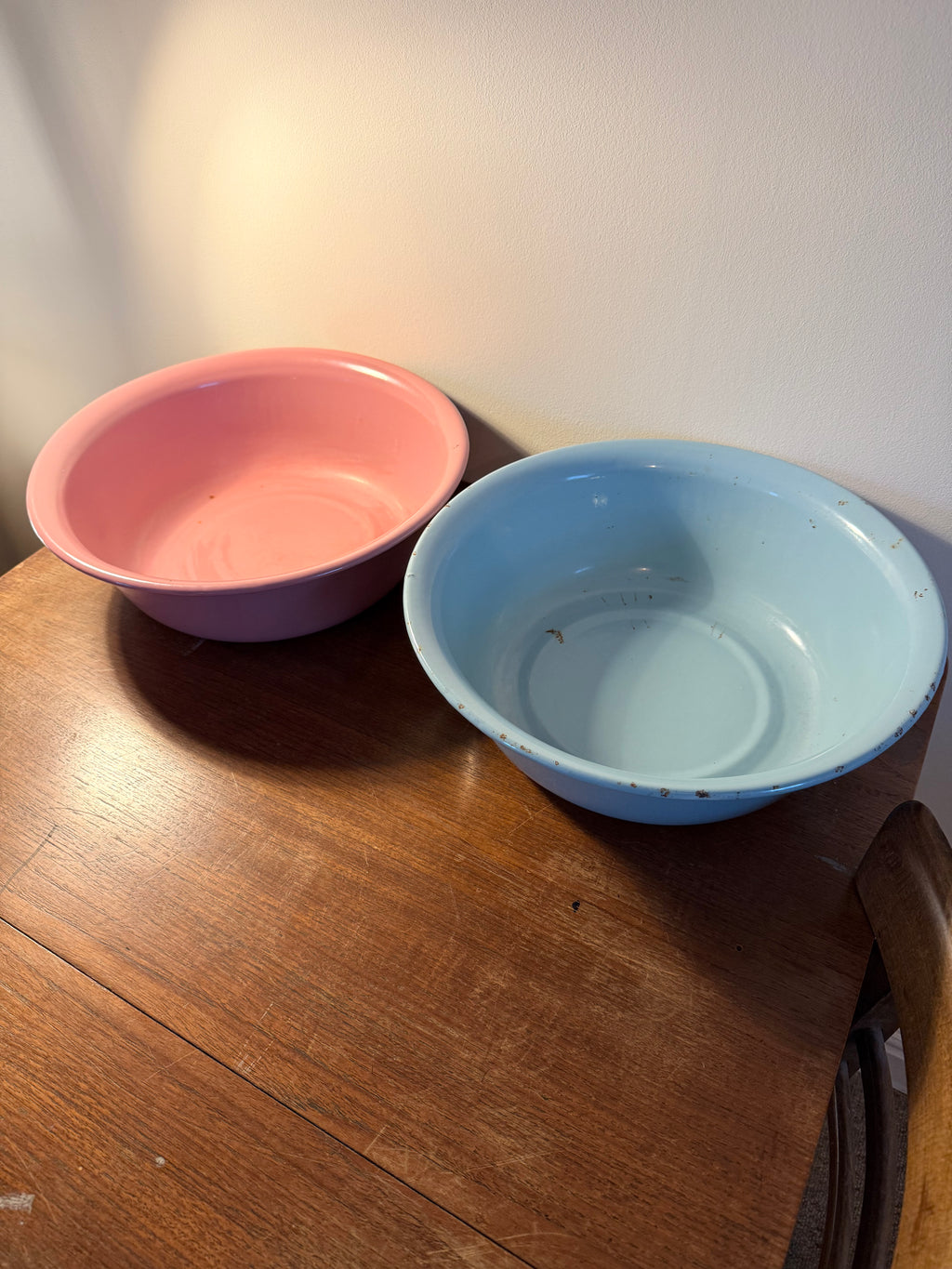 Two vintage enamel basins in soft blush pink and powder blue