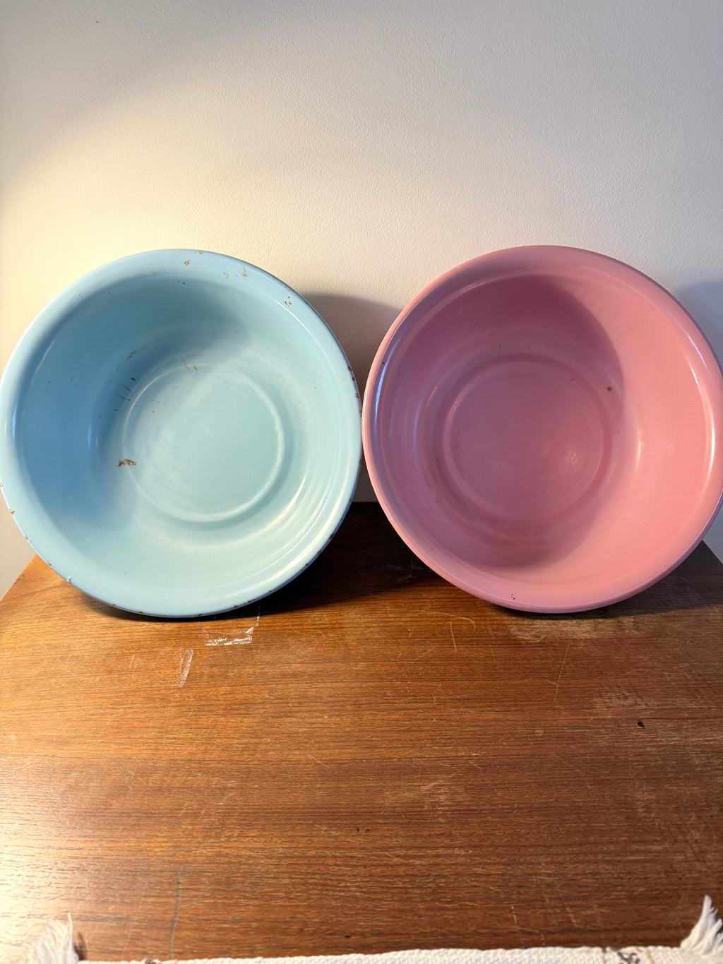Two vintage enamel basins in soft blush pink and powder blue
